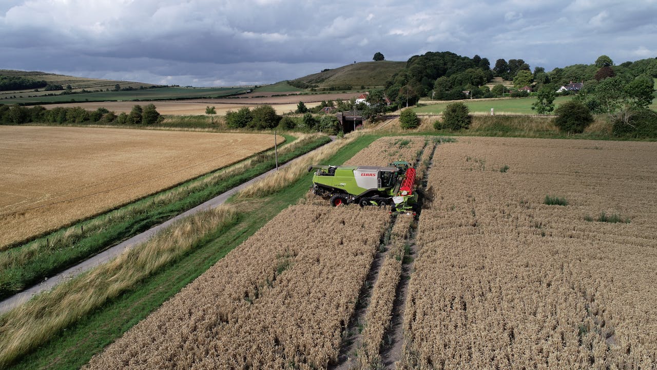 Drone view of a combine harvester on a rural farm in Bishopstrow, England.